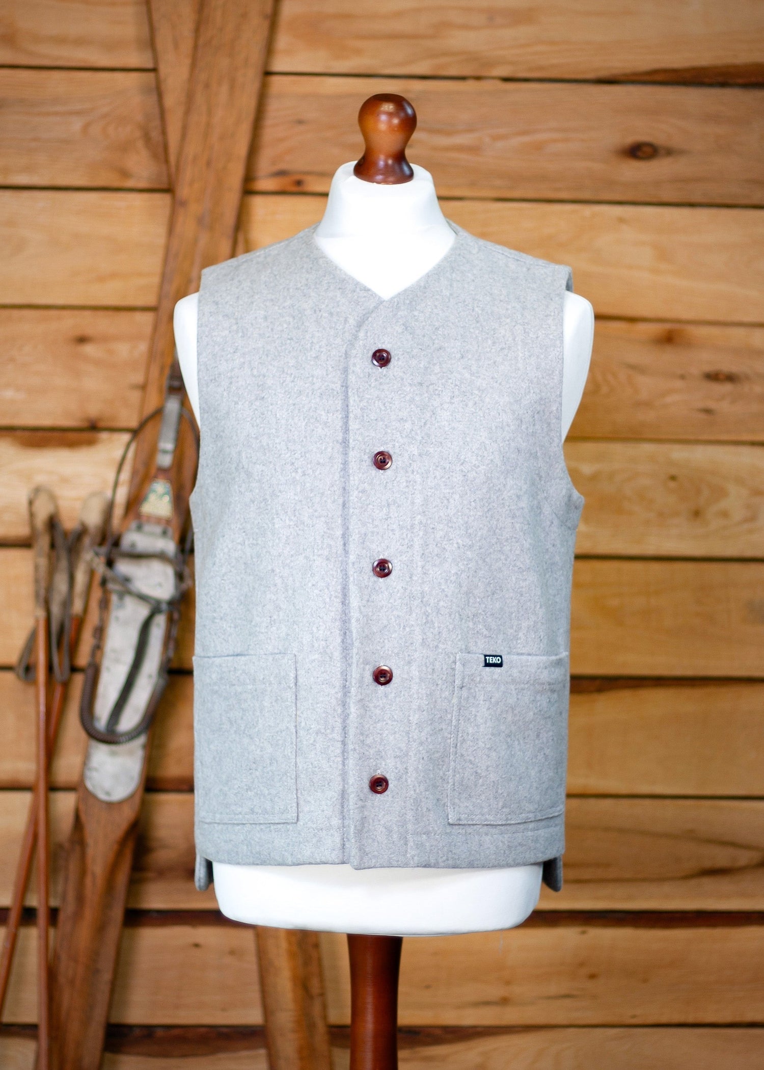 Gray vest on a mannequin against a wooden background