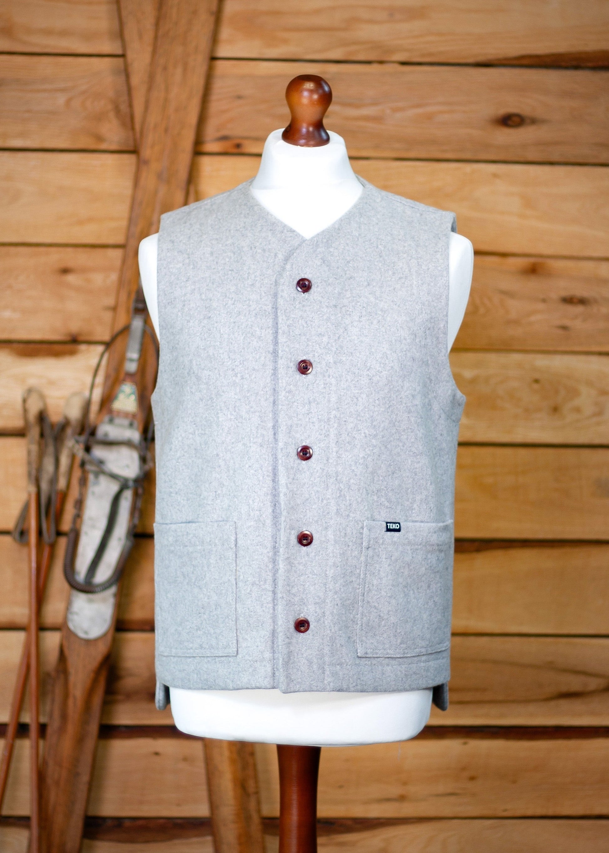 Gray vest on a mannequin against a wooden background